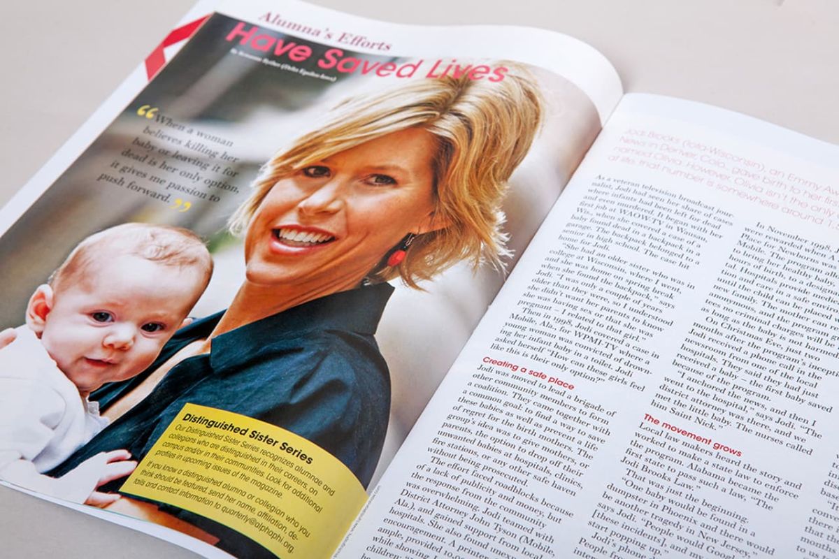 an open copy of the quarterly zoomed on the left page showing a picture of a smiling mother holding a baby